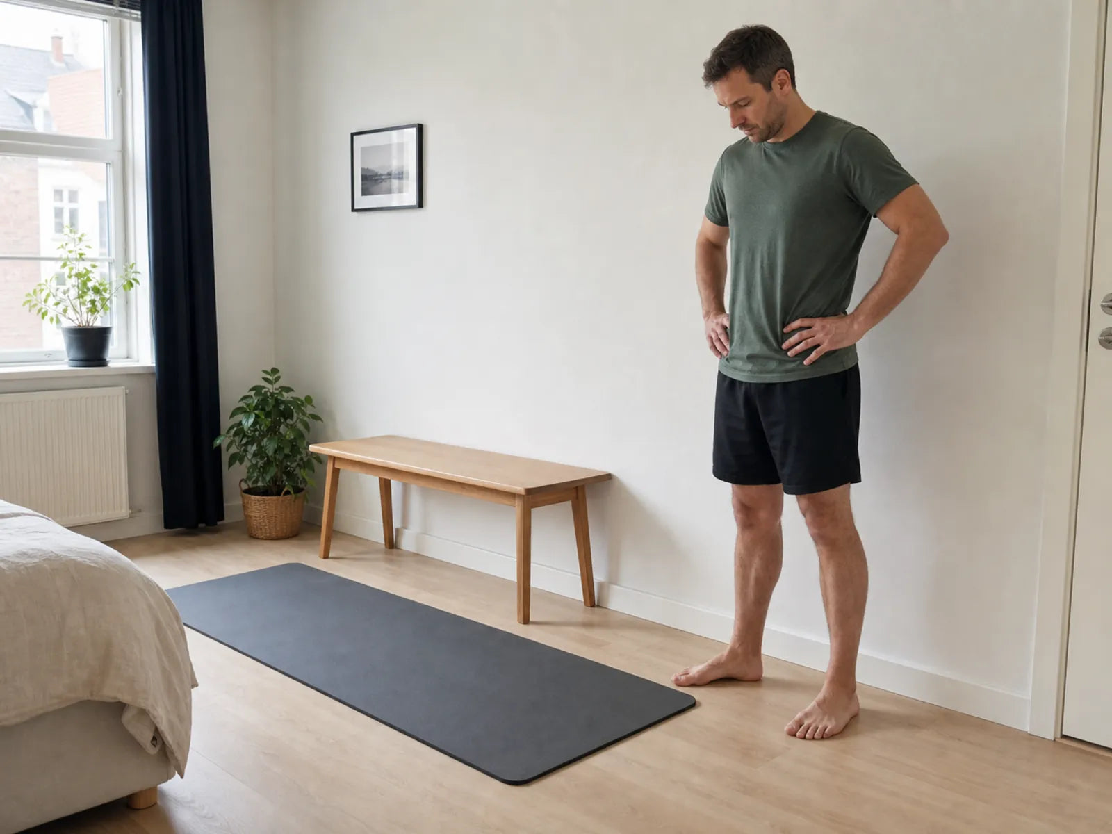 Adult man checks the space at home for hamstring curls with ankle weights.